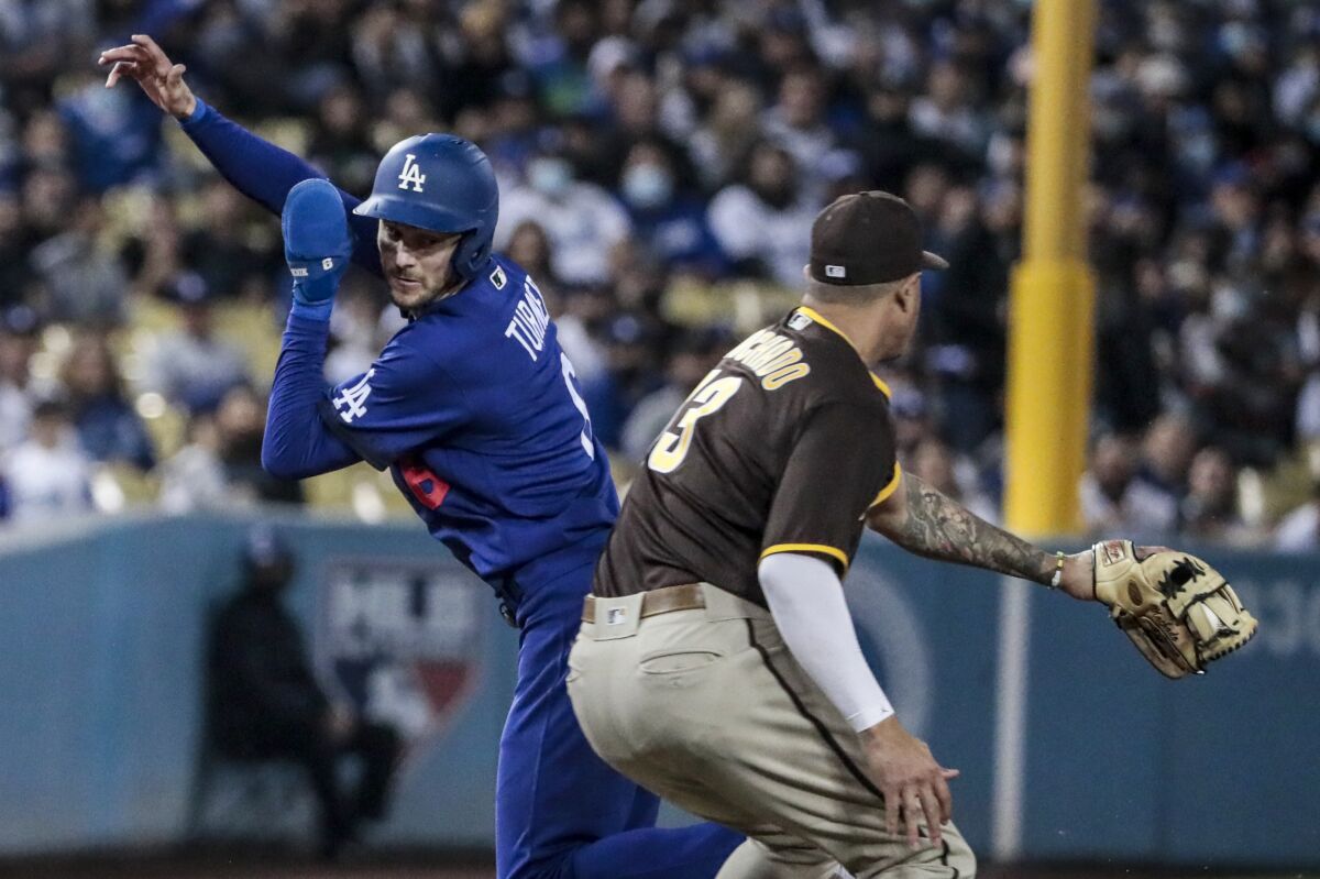 Dodgers second baseman Trea Turner avoids the tag of San Diego Padres third baseman Manny Machado.