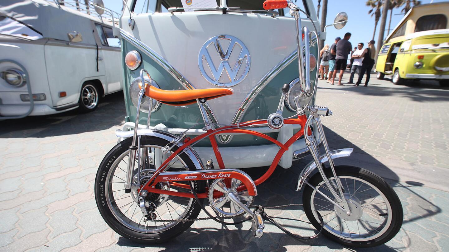 A vintage Schwinn Sting Ray "Orange Krate" goes hand-in-hand with old VW vans during the Kowabunga Van Klan bus rally at the Huntington Beach Pier on Sunday.