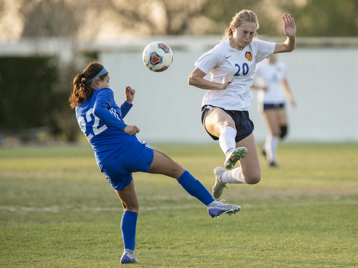 Marina's Samantha Esparza attempts to knock down a ball from Bishop Amat's Mya Partida on Friday.