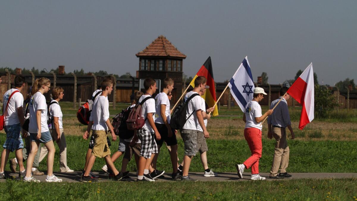 Participants carry German, Israeli and Polish flags as they take part in the March of the Living in 2012 to commemorate victims of the Auschwitz-Birkenau concentration camps in Oswiecim, Poland.
