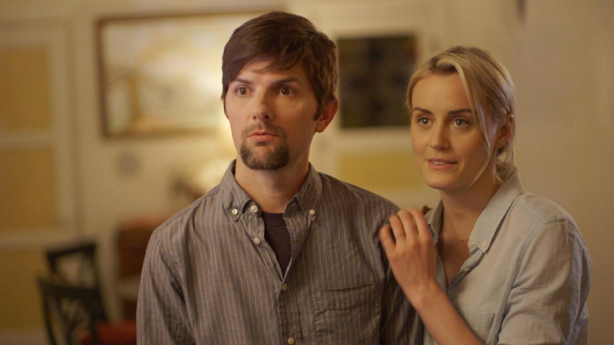Adam Scott, left, and Taylor Schilling, in a scene from the film "The Overnight."