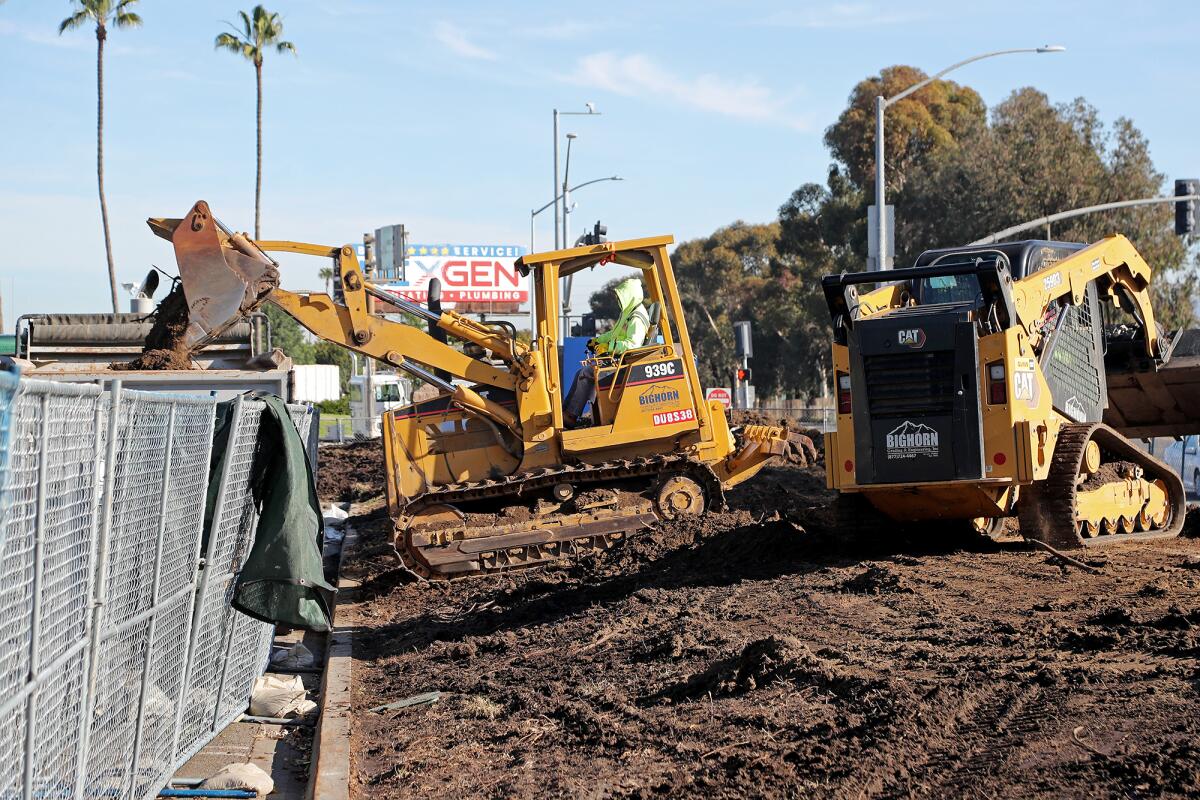 Workers clear dirt near Fair Drive and Newport Boulevard Thursday at Vanguard University in Costa Mesa.