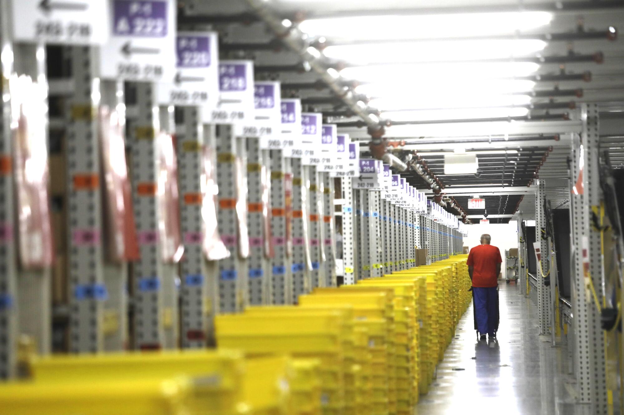 A long line of yellow plastic crates inside a warehouse setting.