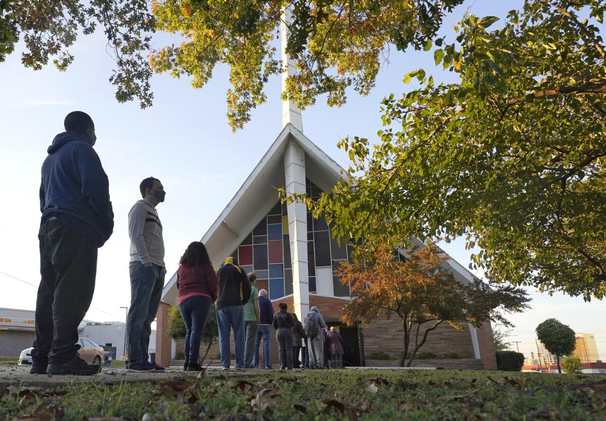 Fotografía de votantes haciendo fila frente a la Iglesia Bautista Vickery para votar en Dallas. 