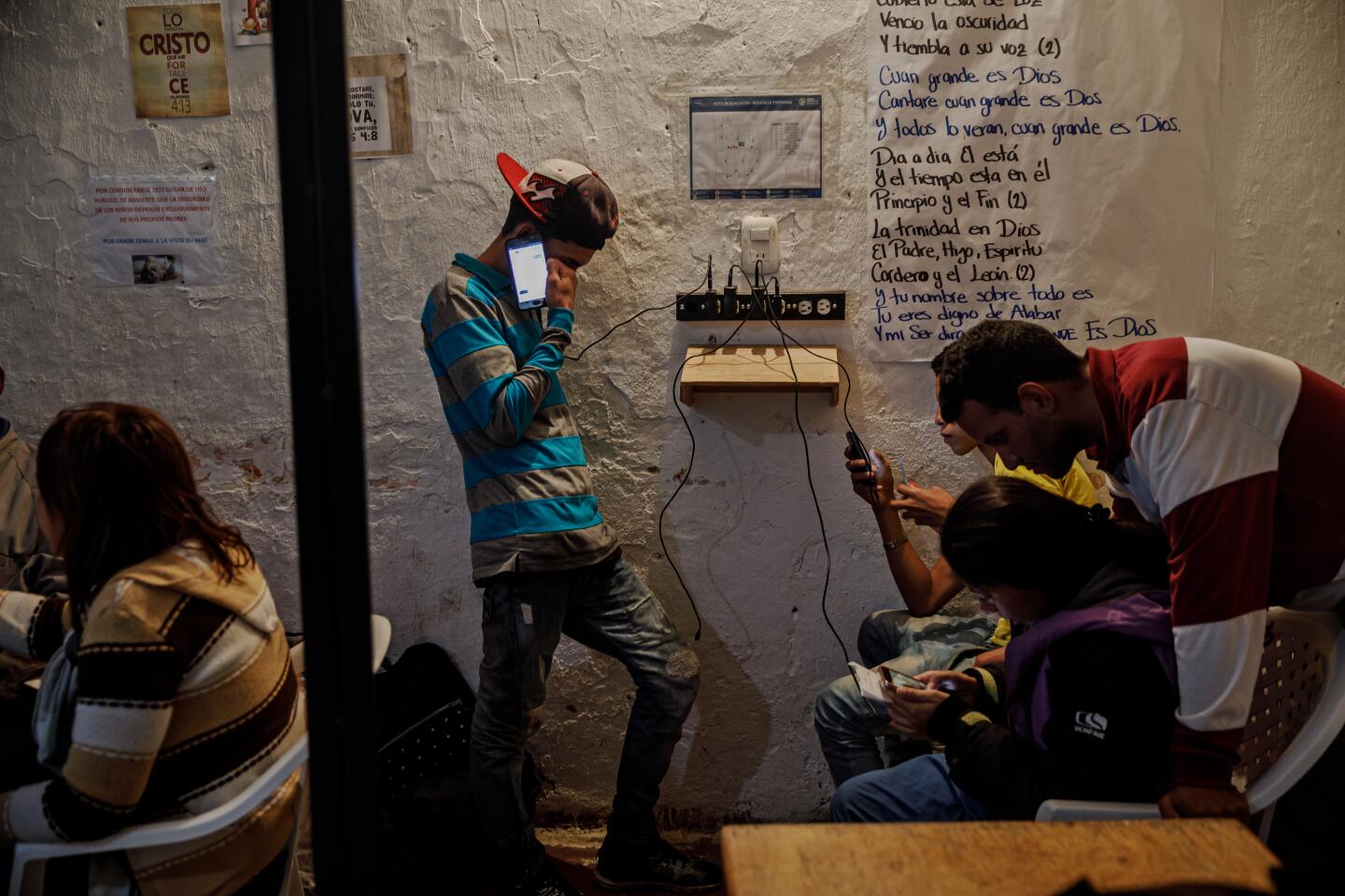 Migrants recharge their phones.