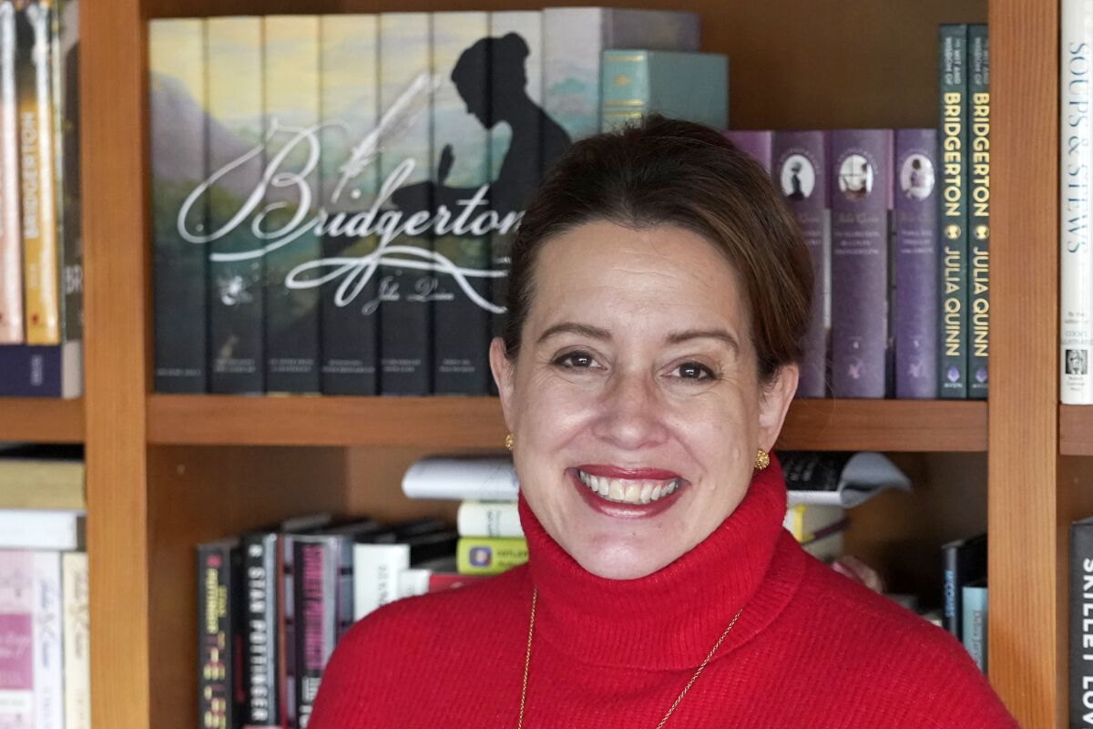 Julia Quinn, the author of the Bridgerton book series, poses at her home in Seattle on March 8, 2022. Two seasons of the "Bridgerton" series, based on Quinn's books, are currently streaming on Netflix. (AP Photo/Ted S. Warren)