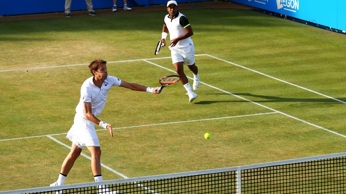 Daniel Nestor hit an overhead smash in front of double partner Leander Paes during a double match against Rafael Nadal and Marc Lopez in the quarterfinals of the Aegon Championships on June 18.
