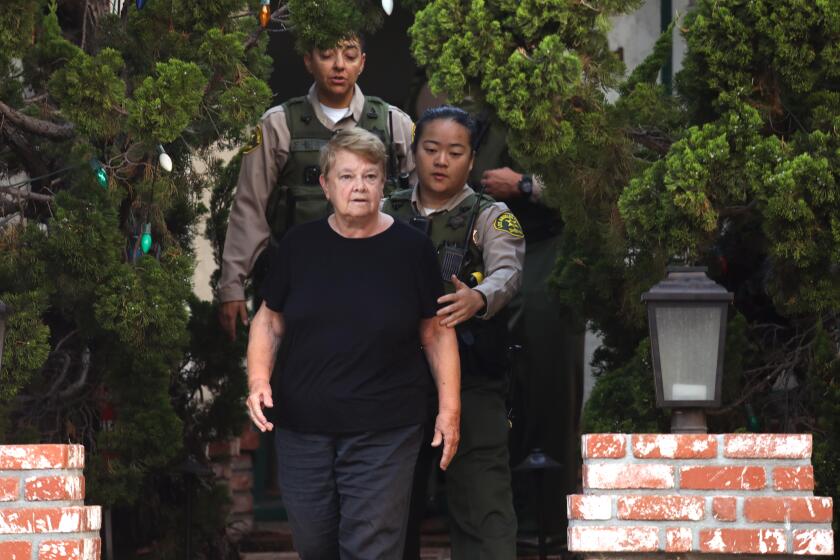 SANTA MONICA, CA - SEPTEMBER 14, 2022 - - Los Angeles County sheriffs escort Los Angeles Supervisor Shelia Kuehl's from her house after serving her an early morning search warrant in Santa Monica on September 14, 2022. This was part of a criminal investigation into a county contract awarded to a nonprofit organization. Sheriff's investigators also searched Patti Giggans' house, her nonprofit's offices, officers at the L.A. County Hall of Administration and the headquarters of the county's Metropolitan Transportation Authority, which awarded a contract to Giggans' Peace Over Violence." (Genaro Molina / Los Angeles Times)