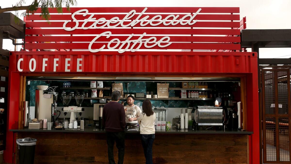 Michael Foss, 27, serves coffee out of a metal shipping container at Steelhead Coffee at the open-air food court Steelcraft in Long Beach.