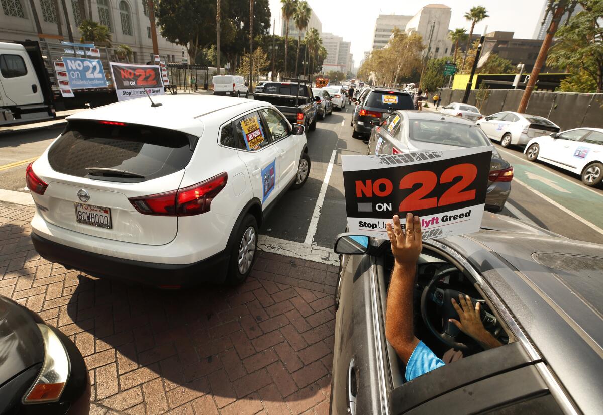 Rideshare driver Jorge Vargas raises his "No on 22" sign