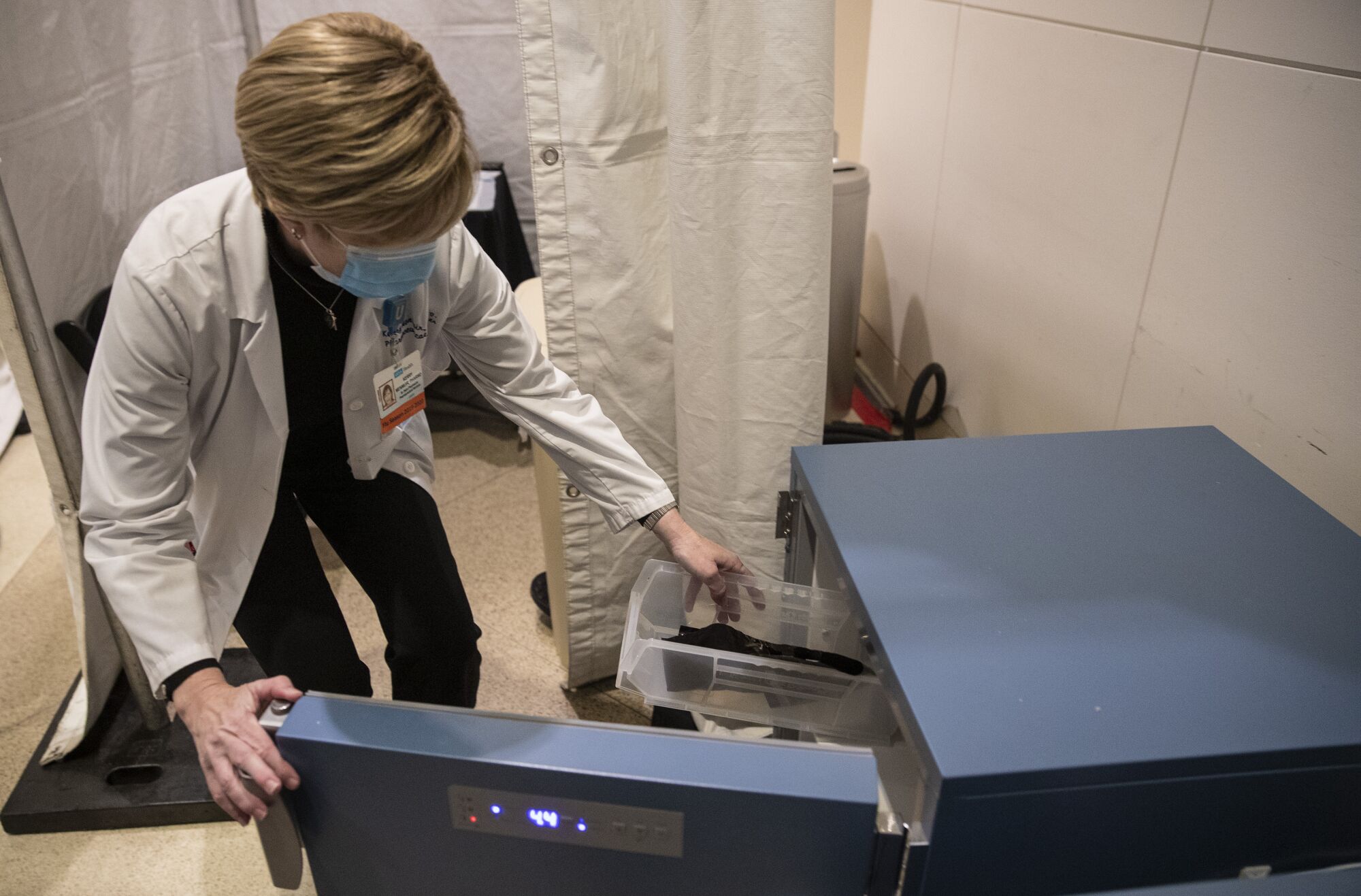 Kerry Menmuir, director of inpatient pharmacy, stores doses of the vaccine in a refrigerator