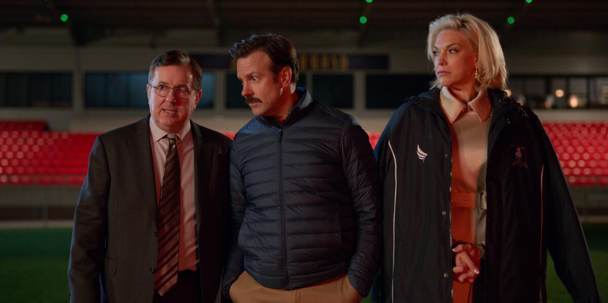 Jeremy Swift, from left, Jason Sudeikis and Hannah Waddingham in a "Ted Lasso" scene on the football pitch.
