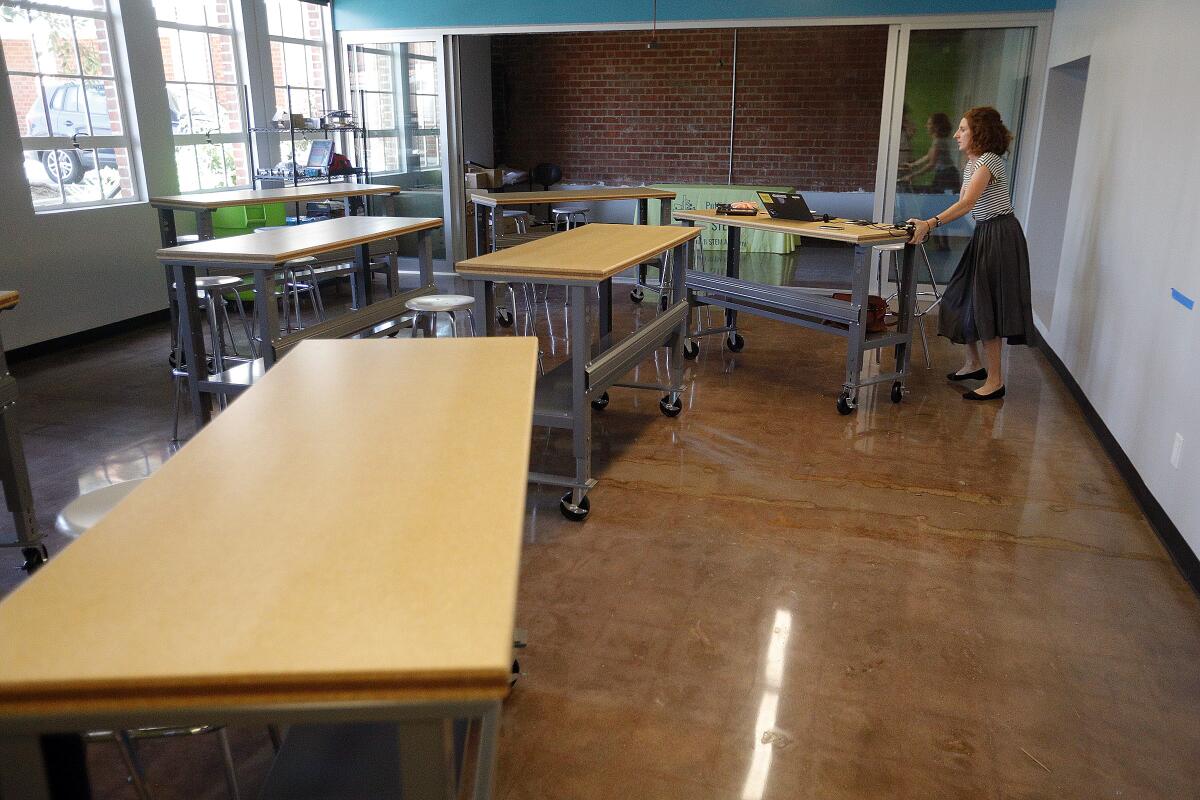 Dean of Academic Excellence Bridget Higgins moves a mobile work bench around in her new STEM classroom at the St. John Paul II STEM Academy in Burbank on Tuesday. The school, in the former Bellarmine-Jefferson High School building, is preparing for its first class of students to start classes this August.