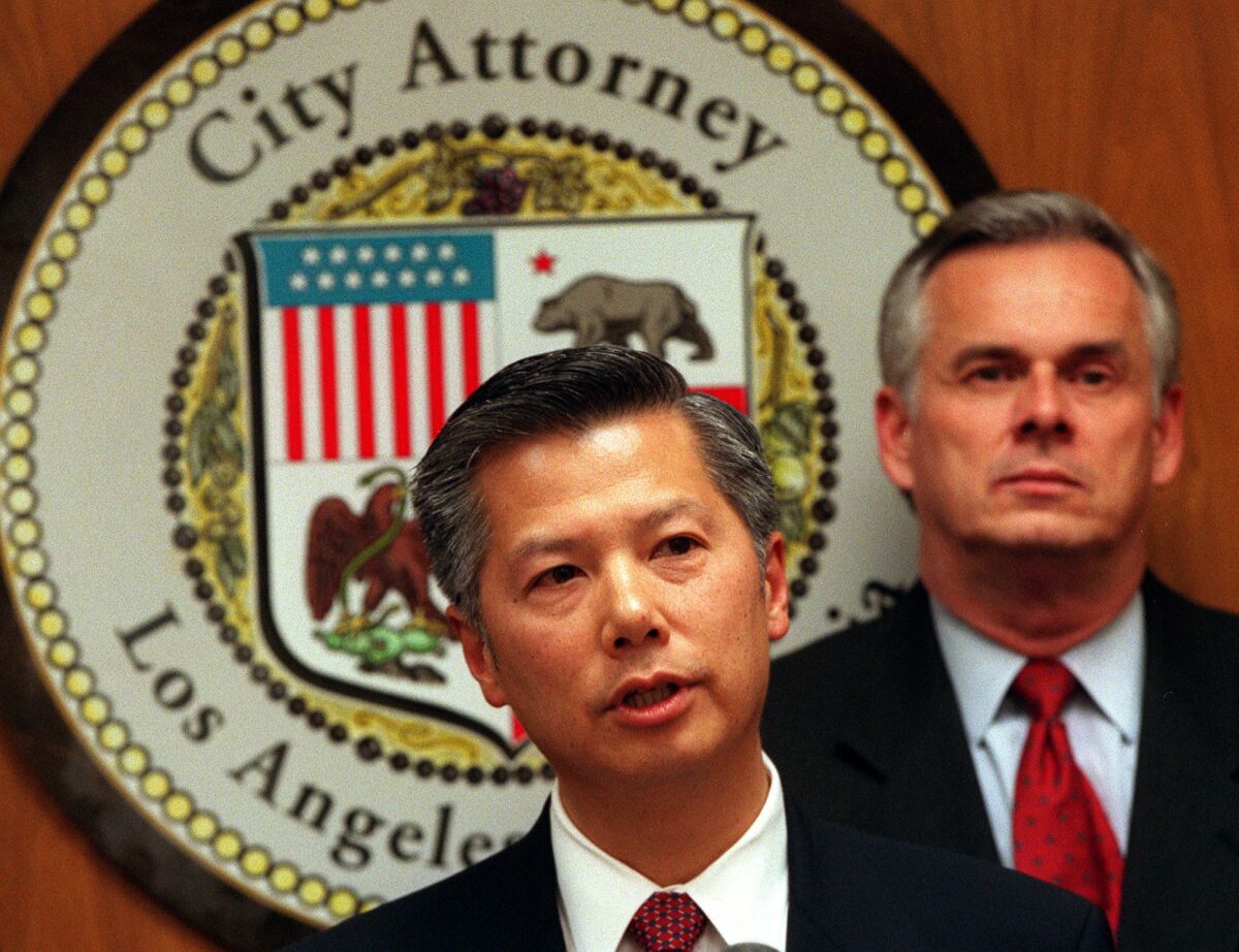 Then-Assistant Atty. Gen. Bill Lann Lee, left, head of the U.S. Justice Department's Civil Rights Division, is joined by former Los Angeles City Atty. Jim Hahn at a news conference in November 2000 after the L.A. City Council's approval of the LAPD consent decree.