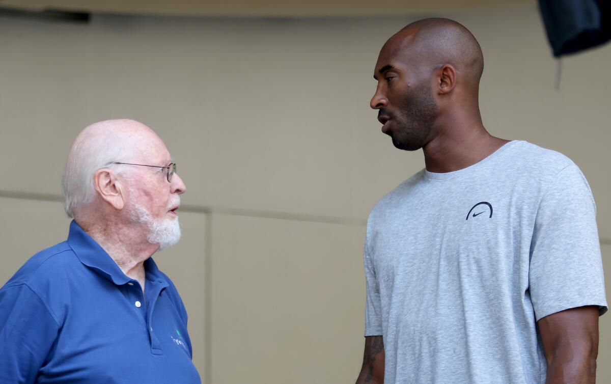 John Williams, left, and Kobe Bryant conferring during rehearsals at the Bowl. (Luis Sinco / Los Angeles Times)