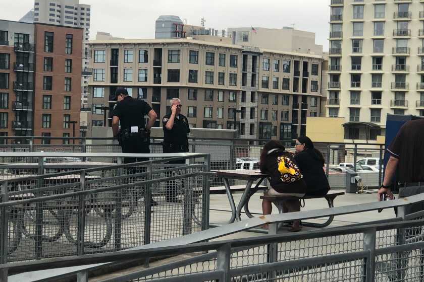 A San Diego police officer looks over side of the Petco concourse after a woman and child fell to their deaths Saturday afternoon before a Padres game.