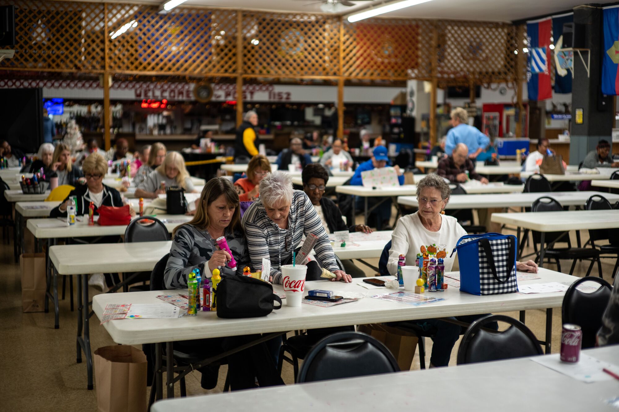 People sit at rows of white tables 