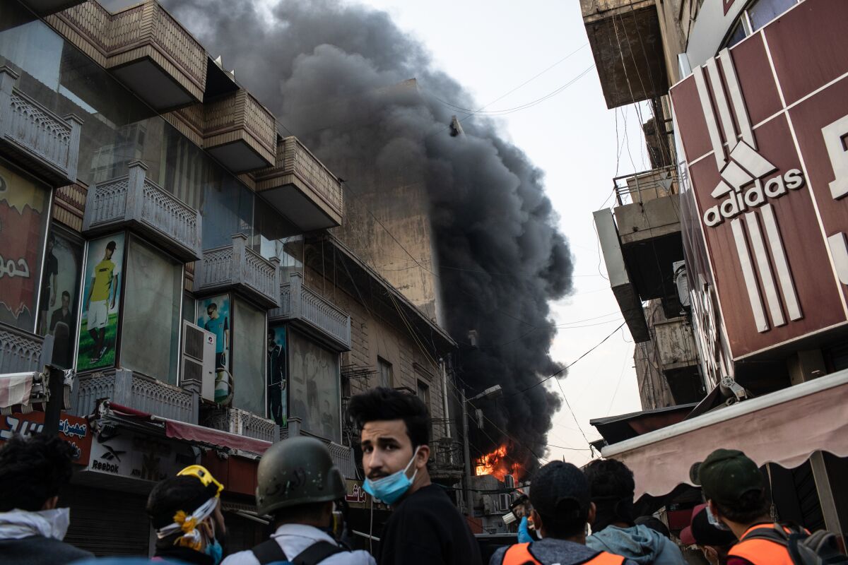 A building is set ablaze near Ahrar Bridge, where there have been recent clashes between demonstrators and Iraq security forces, Sunday in Baghdad. Thousands of demonstrators have occupied central Baghdad since Oct. 1, calling for government and policy reform.
