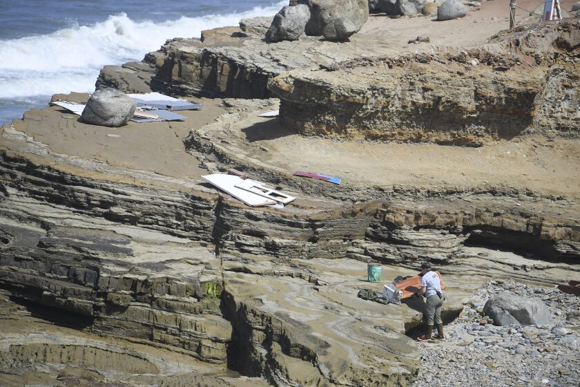 A National Park Service employee removes debris and wreckage from the tide pools at Cabrillo National Monument Monday May 3, 2021 in San Diego. The wreckage came from a boat that ran aground Sunday May 2, 2021. (Photo by Denis Poroy)