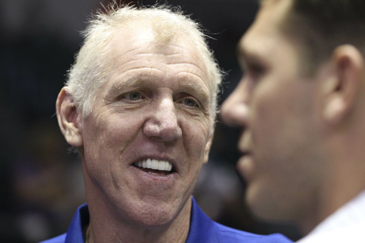 Retired NBA star Bill Walton, left, talks to his son and interim coach of the Golden State Warriors before the start of the NBA preseason game between the Lakers and the Golden State Warriors.