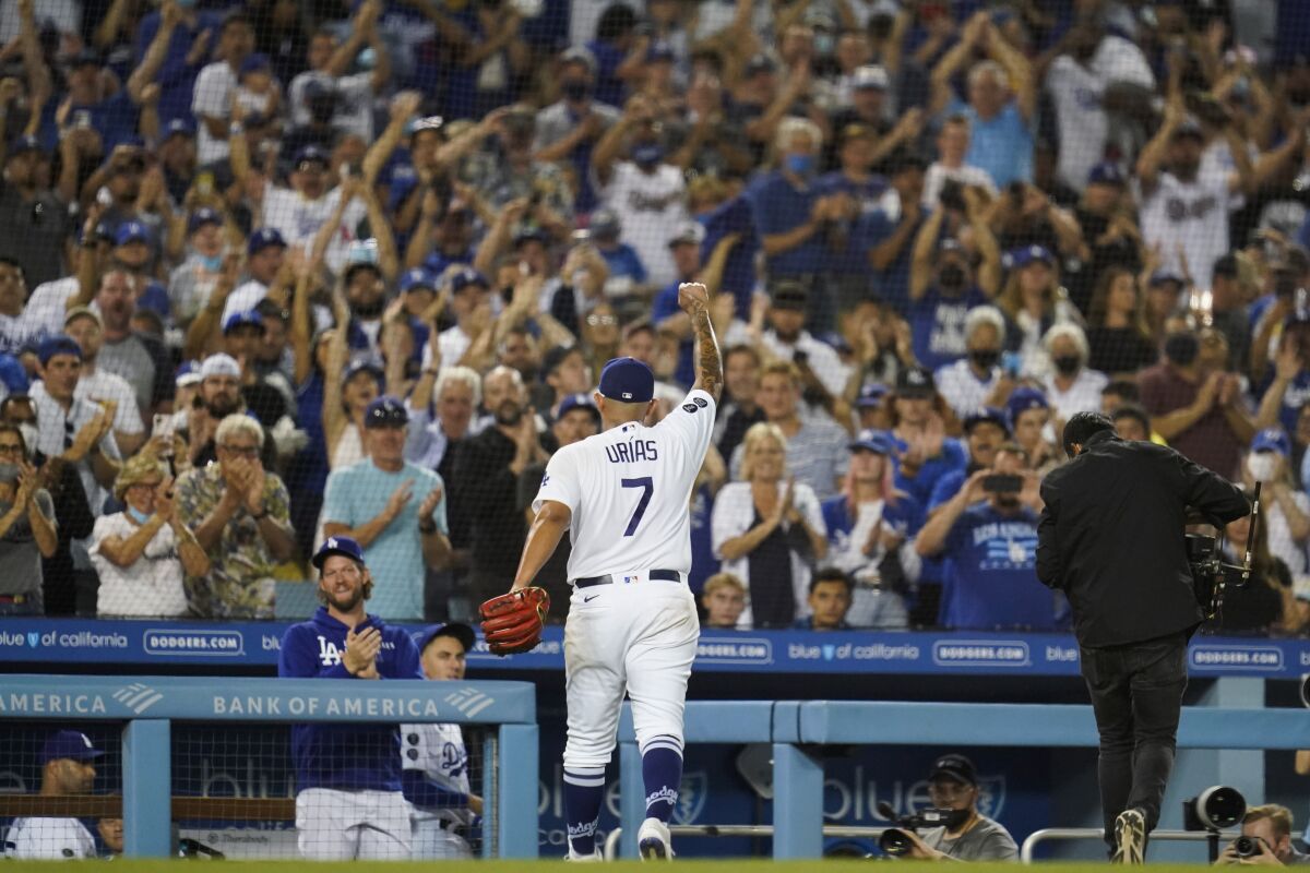 Los Angeles Dodgers relief pitcher Julio Urias (7) raises his fist as he leaves the mound during the seventh inning of a baseball game against the Milwaukee Brewers Saturday, Oct. 2, 2021, in Los Angeles. (AP Photo/Ashley Landis)