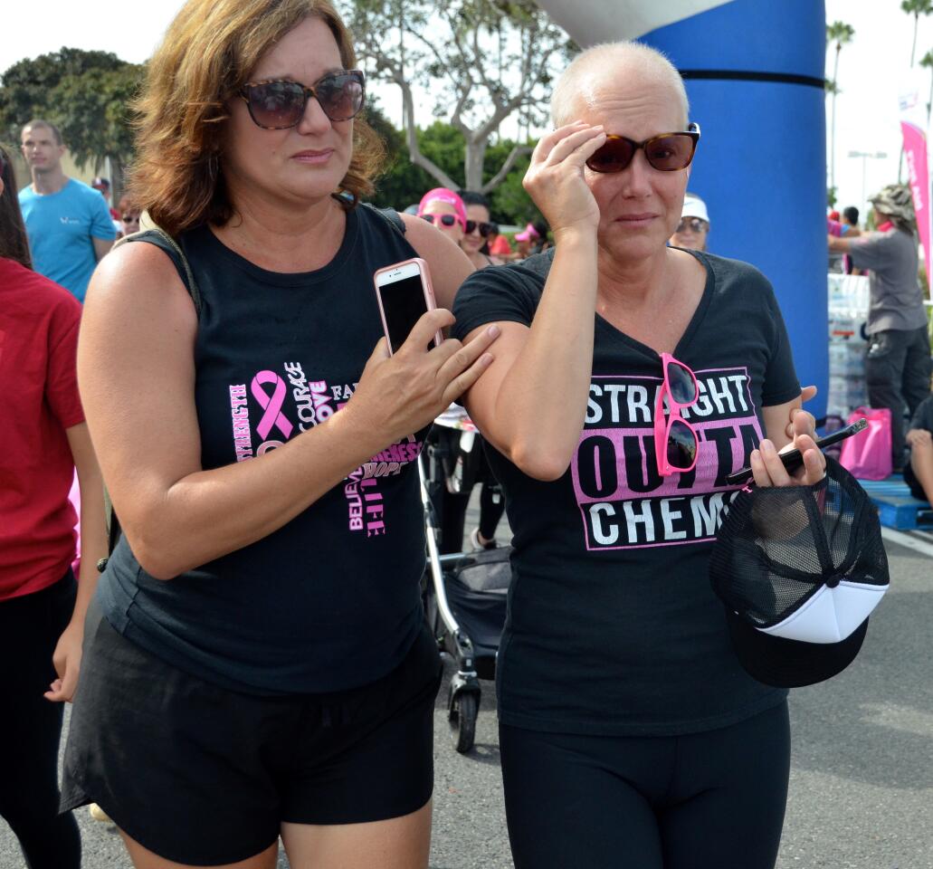 Lucy Polk, left, guides cancer survivor Caroline Smith to the finish line of the More than Pink Walk on Sunday. The event, held near Fashion Island in Newport Beach, raised money for breast cancer research.