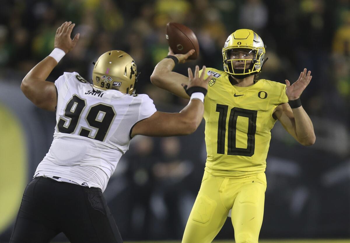 Colorado's Jalen Sami, left, rushes Oregon's Justin Herbert during the first quarter on Friday in Eugene, Ore.