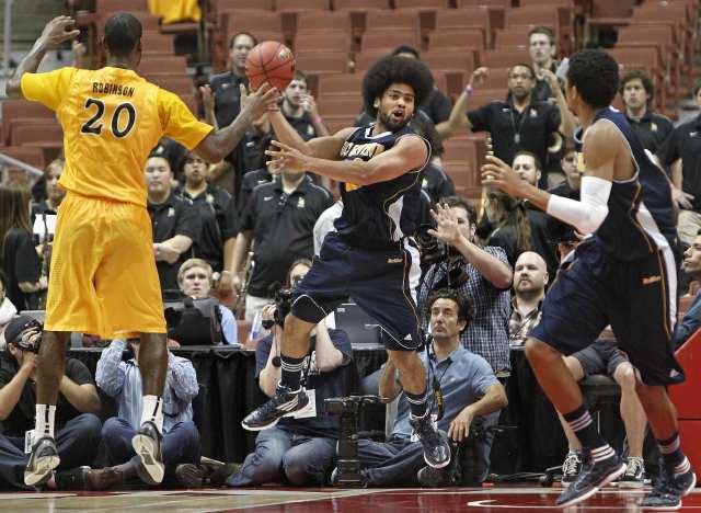 UC Irvine's Michael Wilder, center, saves the ball from going out of bounds.