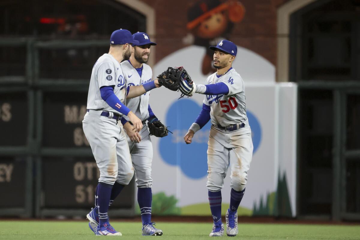 Dodgers outfielders (from left) AJ Pollock, Chris Taylor and Mookie Betts celebrate a 9-2 win.