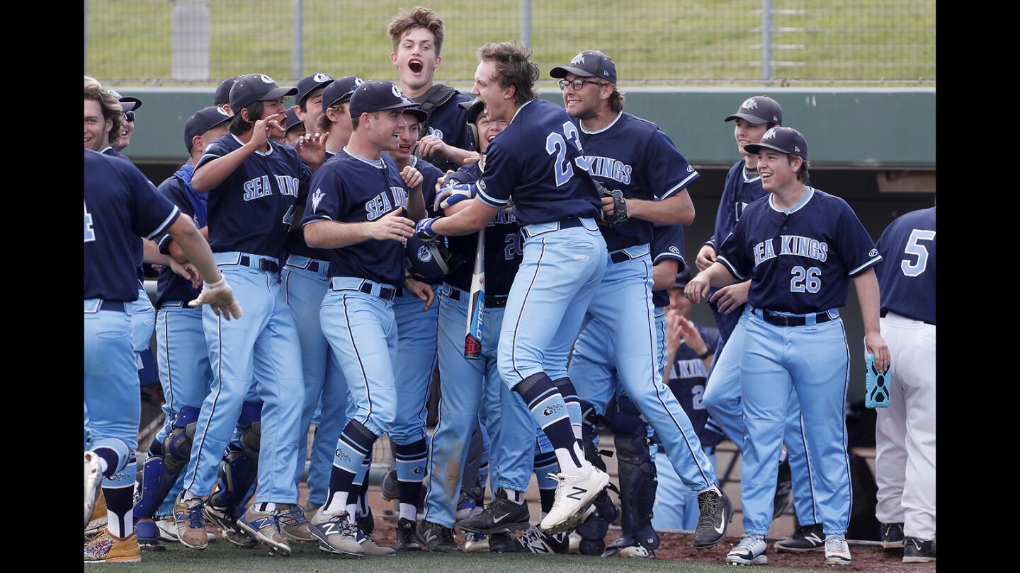 Corona del Mar High's Luc Stuka, center, cheers as he celebrates his three-run homer during the second inning against Newport Harbor in the Battle of the Bay rivalry game at UC Irvine's Anteater Ballpark on Saturday, March 24.