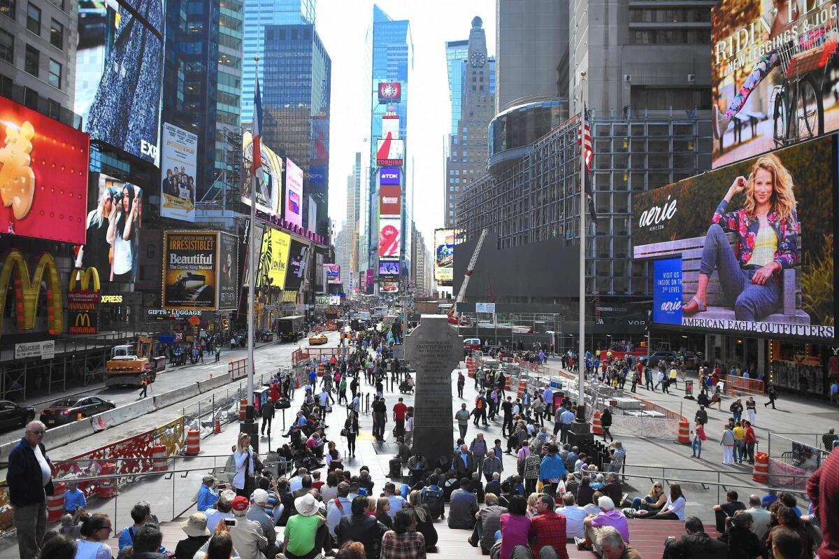 Economists said the slight increase in third-quarter borrowing for auto and student loans and credit card balances was an indication that households felt more comfortable taking on credit to fund current consumption. Above, tourists enjoy the atmosphere in Times Square in New York in October.