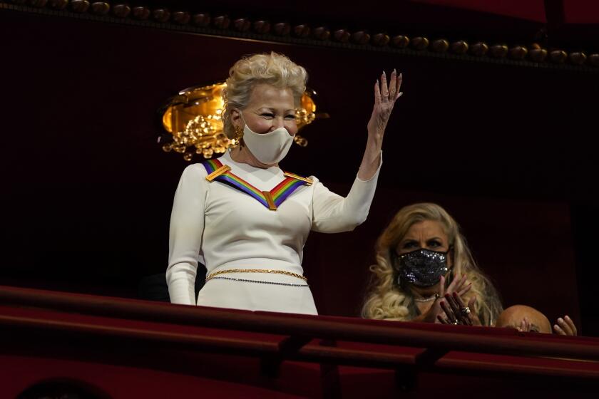 Actress-singer Bette Midler waves to the crowd upon arriving at the 44th Kennedy Center Honors at the John F. Kennedy Center for the Performing Arts in Washington, Sunday, Dec. 5, 2021. The 2021 Kennedy Center honorees include Midler, Motown Records creator Berry Gordy, "Saturday Night Live" mastermind Lorne Michaels, opera singer Justino Diaz and folk music legend Joni Mitchell. (AP Photo/Carolyn Kaster)