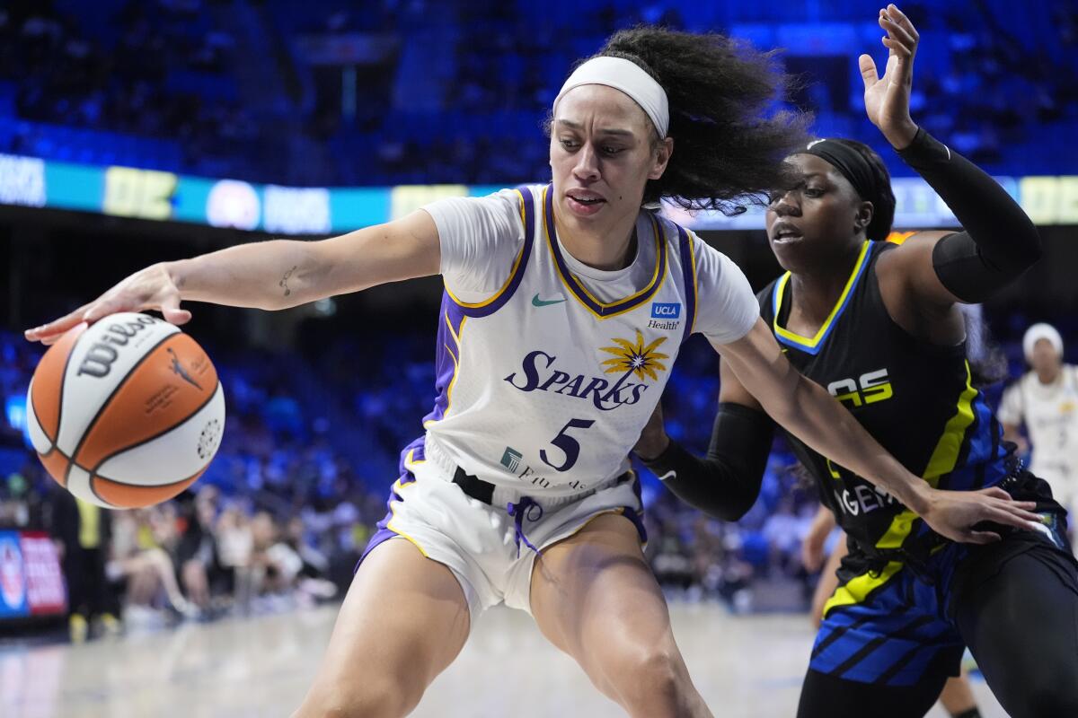 Sparks forward Dearica Hamby, left, controls the ball in front of Dallas Wings guard Arike Ogunbowale.