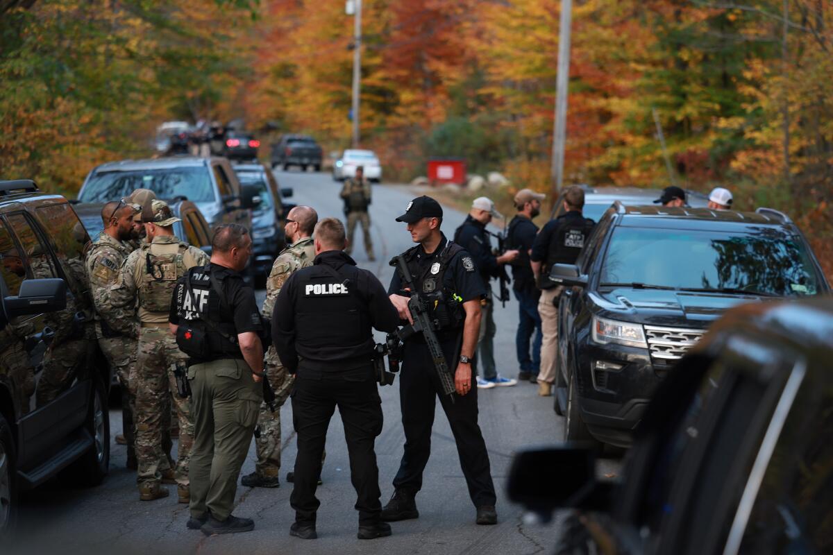 Law enforcement officers gather in a roadway.