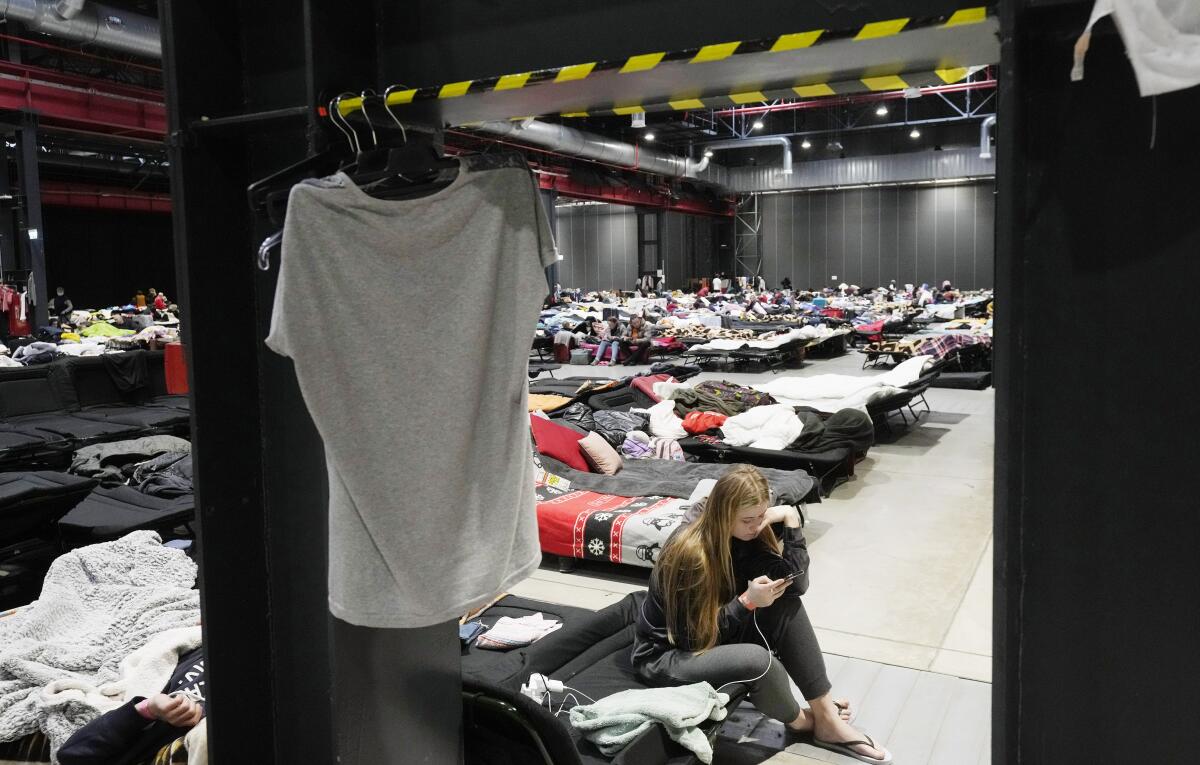 Refugees from Ukraine stay inside a vast accommodation center set up in an exhibition hall in Poland.