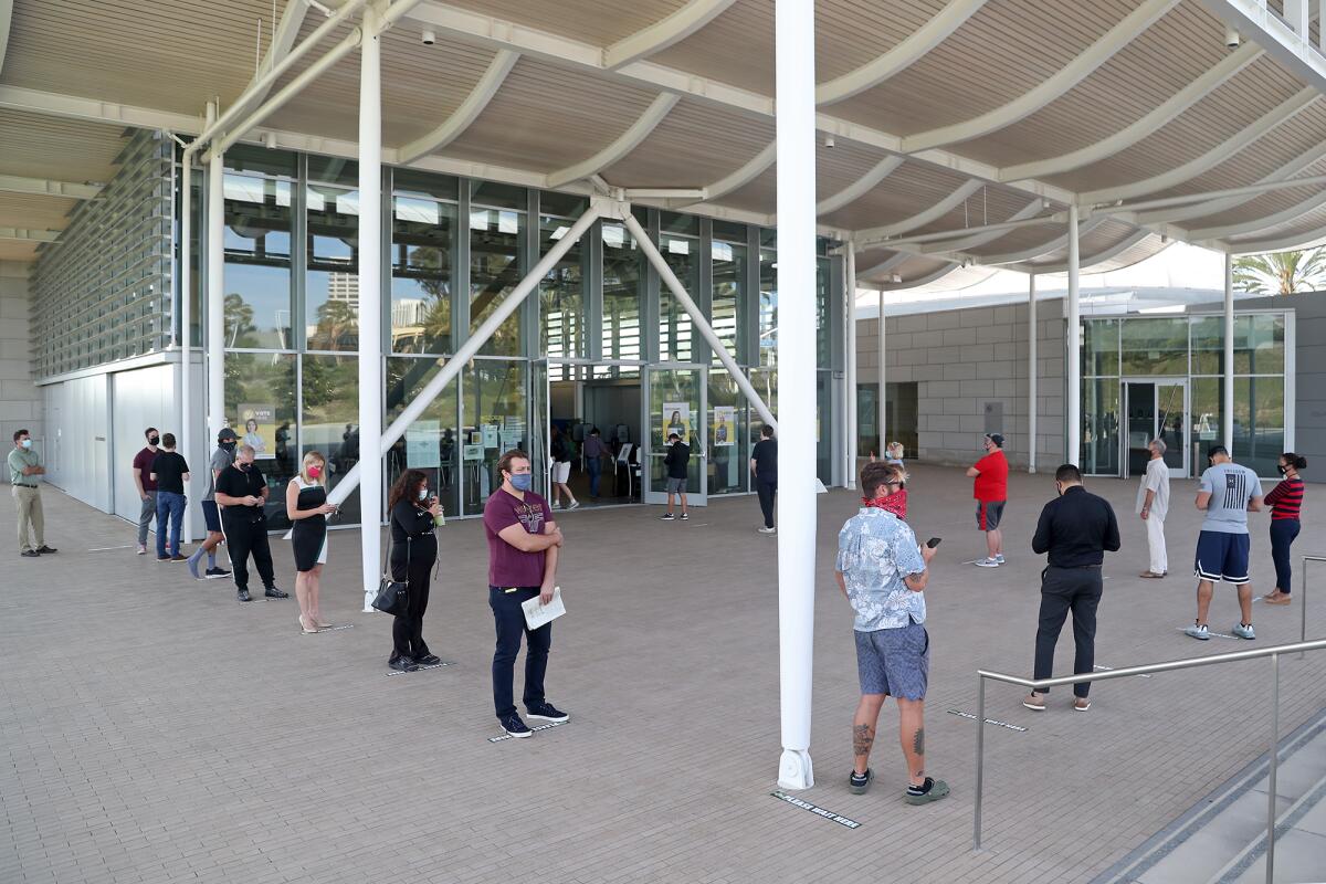 Voters practice social distancing as they wait in line to cast their ballots at Newport Beach Civic Center.