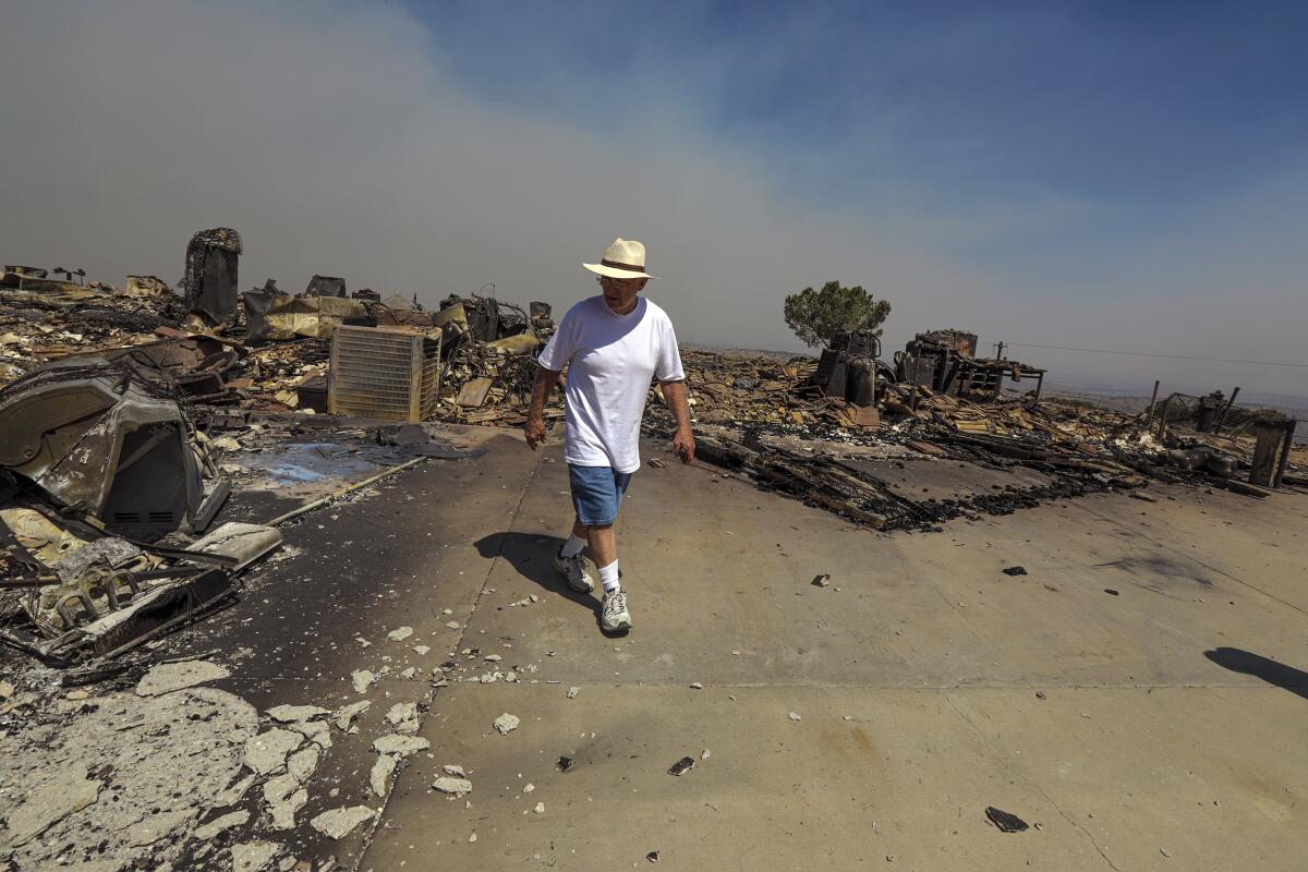 Roland Pagan surveys the remains of his home that was burned to the ground by the Bobcat fire.