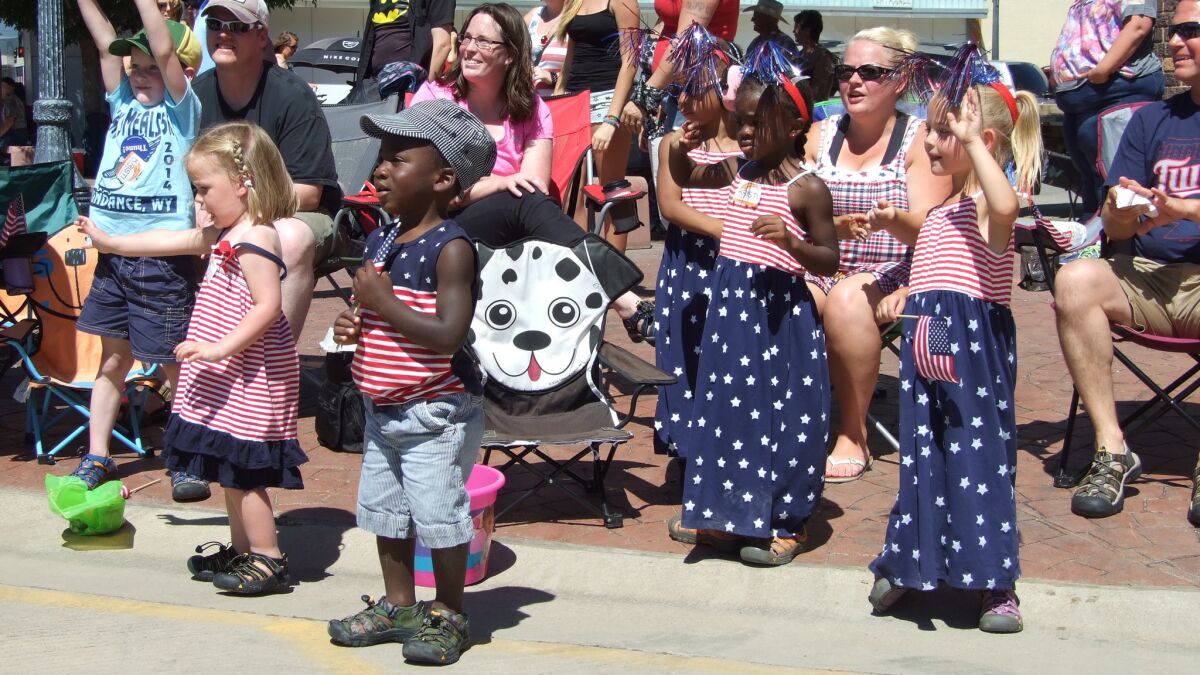 Children dressed in red, white and blue watch the Fourth of July parade in Belle Fourche, S.D.