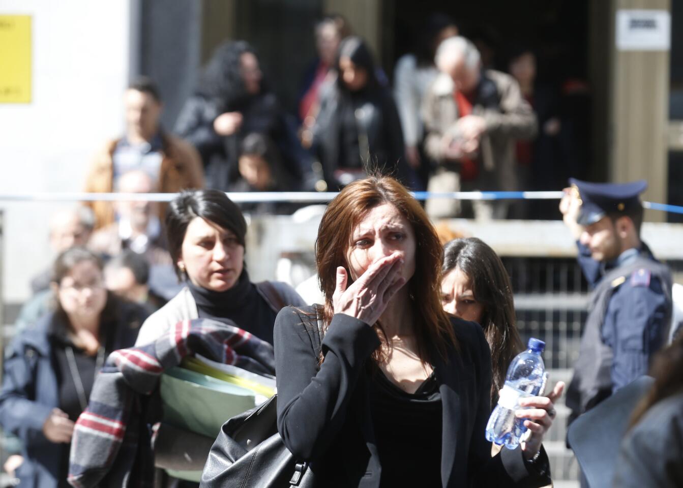 Evacuees trickle out of the Milan, Italy, courthouse as police search inside for the gunman. A suspect was captured on motorbike.