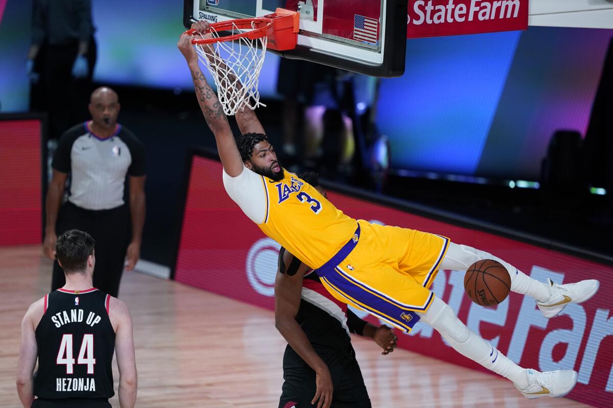 Lakers forward Anthony Davis dunks over Portland Trail Blazers forward Mario Hezonja during the second half.