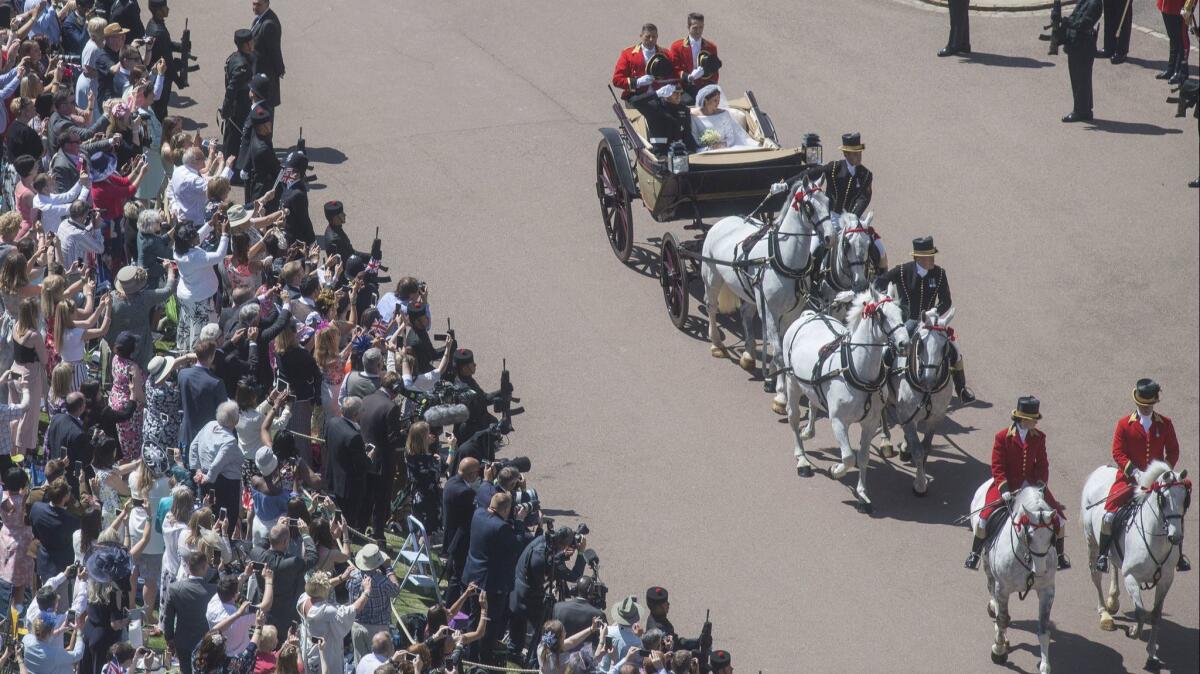 Crowds wave to Harry and Meghan after their wedding at Windsor Castle.