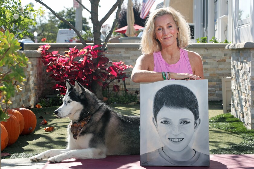 Newport Beach resident Amy Von Der Ahe poses with a portrait of her son Johnny and his dog Koda, a 5-year-old Husky.