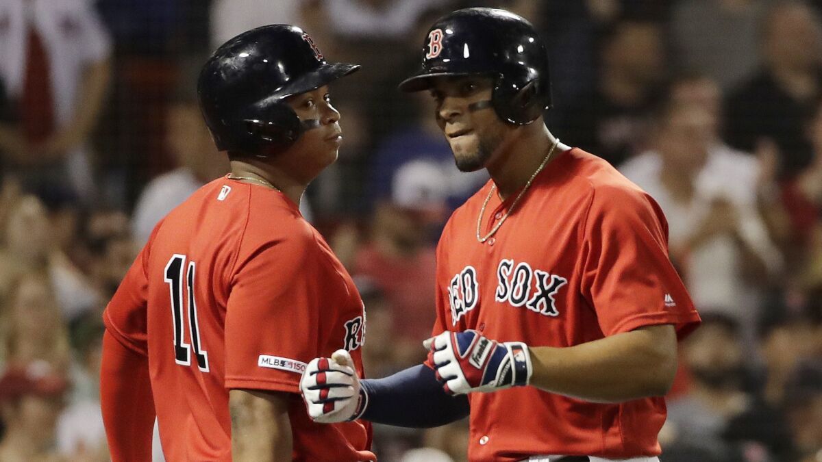 Boston Red Sox's Xander Bogaerts, right, celebrates his three-run home run with Rafael Devers during the seventh inning against the Dodgers on Friday in Boston.