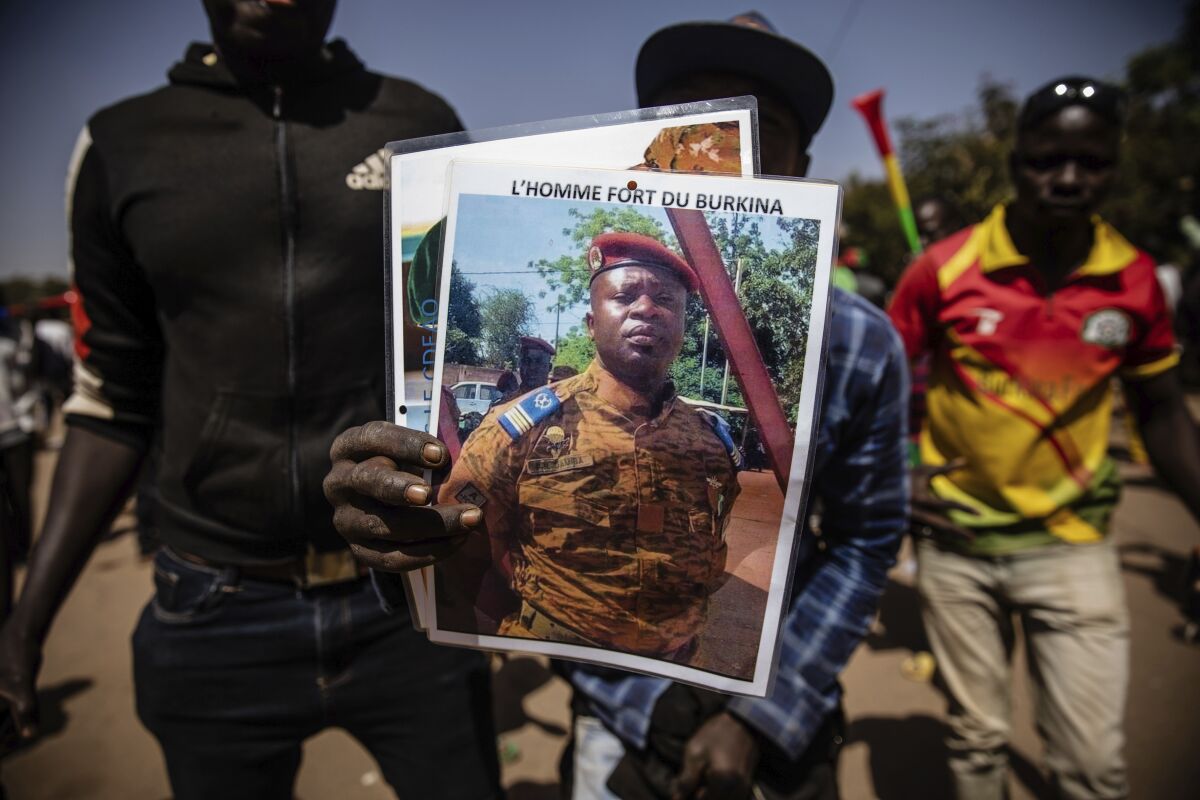 FILE - A man holds a portrait of Lt. Col. Paul Henri Sandaogo Damiba who has taken the reins of Burkina Faso, in Ouagadougou, Jan. 25, 2022. West Africa is grappling with a wave of military coups over the past 18 months that has some wondering which country could be next. (AP Photo/Sophie Garcia, File)