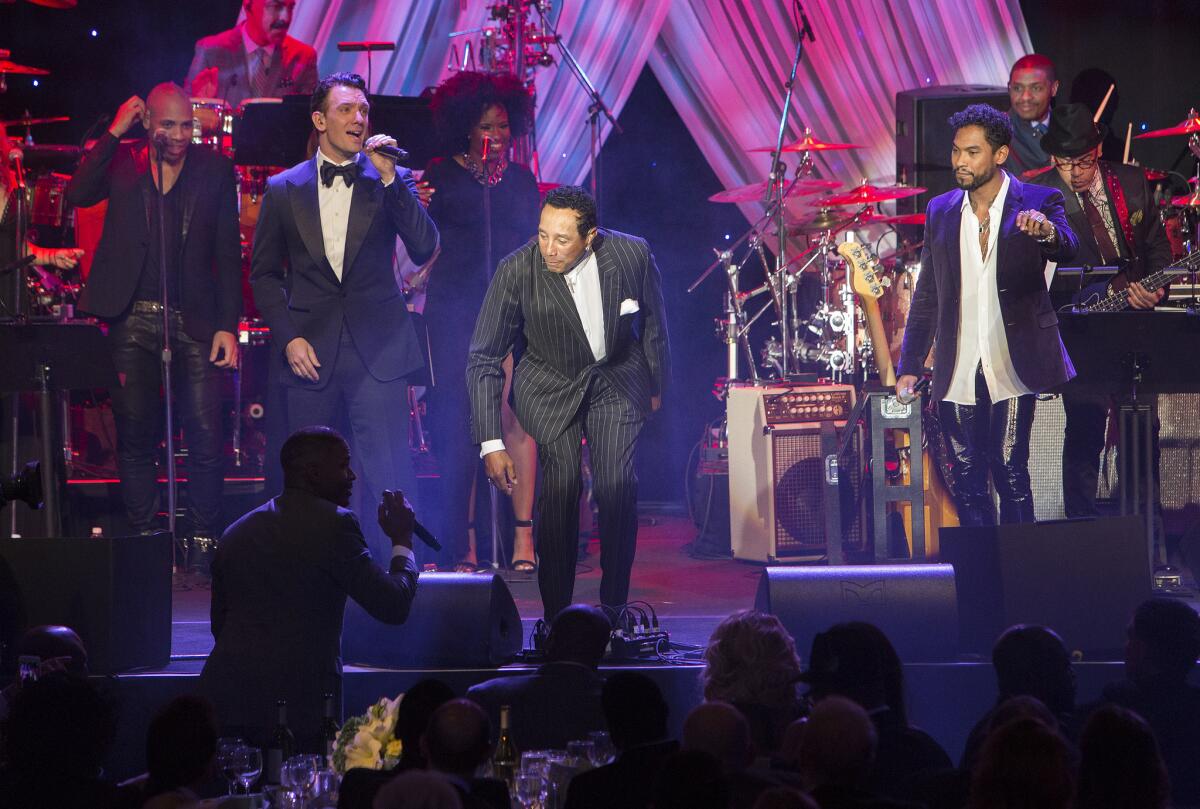 Smokey Robinson hands the microphone to Jamie Foxx in the audience during Clive Davis' pre-Grammy gala Saturday night at the Beverly Hilton.