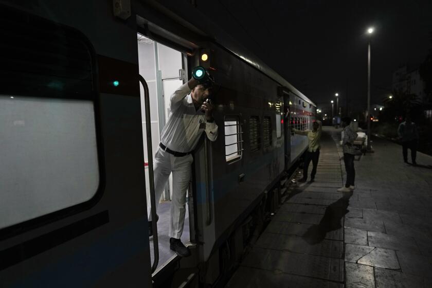 A railway guard shows the signal for the train to start, on board the Thirukkural Express at Nizamuddin railway station in New Delhi, Saturday, April 20, 2024. The Thirukkural Express stretches from New Delhi, the heart of India, to Kanyakumari, India's southernmost tip. (AP Photo/Manish Swarup)