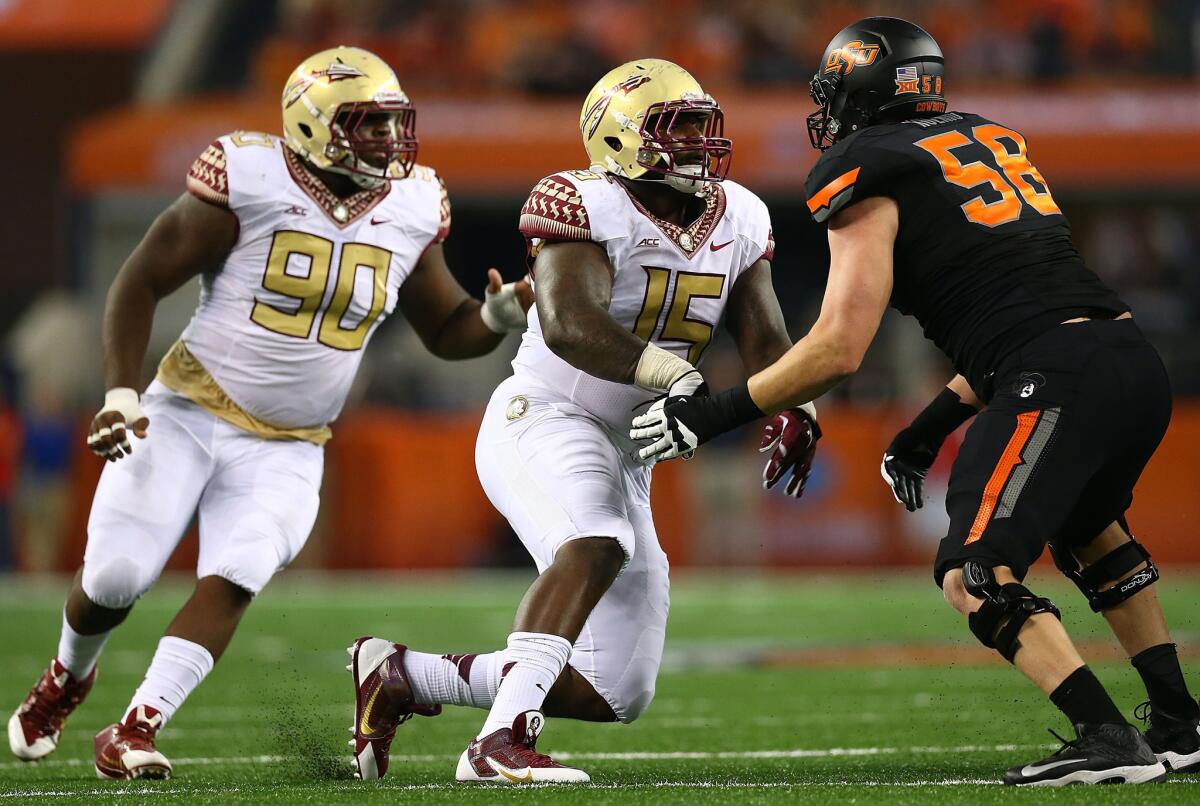 Florida State defensive ends Eddie Goldman (90) and Mario Edwards Jr. rush Oklahoma State offensive tackle Daniel Koenig during a game on Aug. 30.