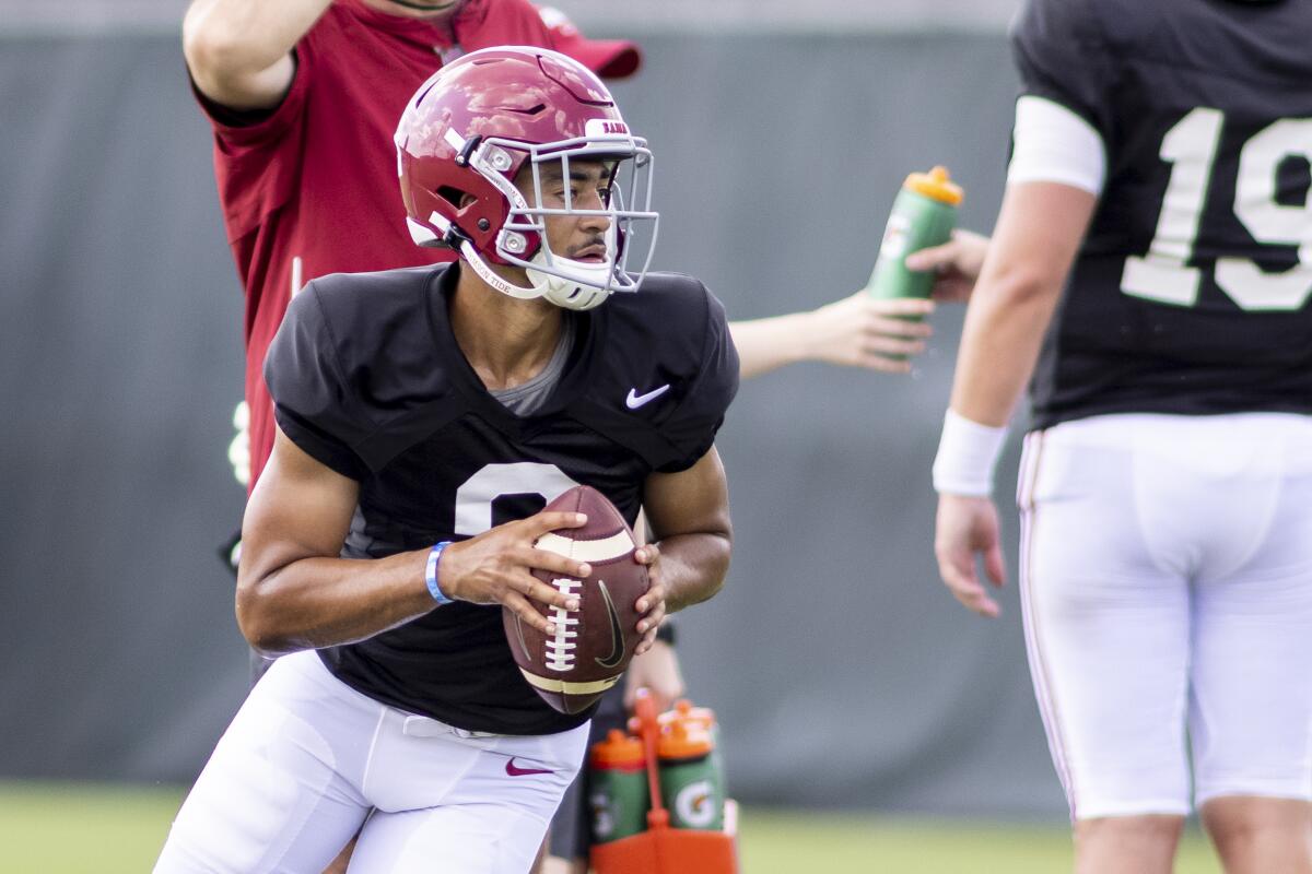 Alabama quarterback Bryce Young (9) rolls out on a passing drill 