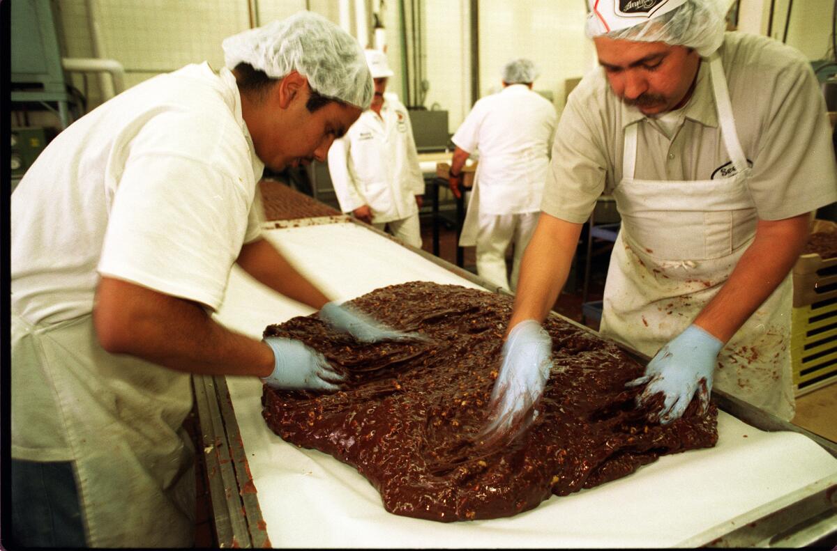 FO.See's@@#21.IS.12/18/96.Fudge is spread on table after nuts are mixed in at the See's factory. 