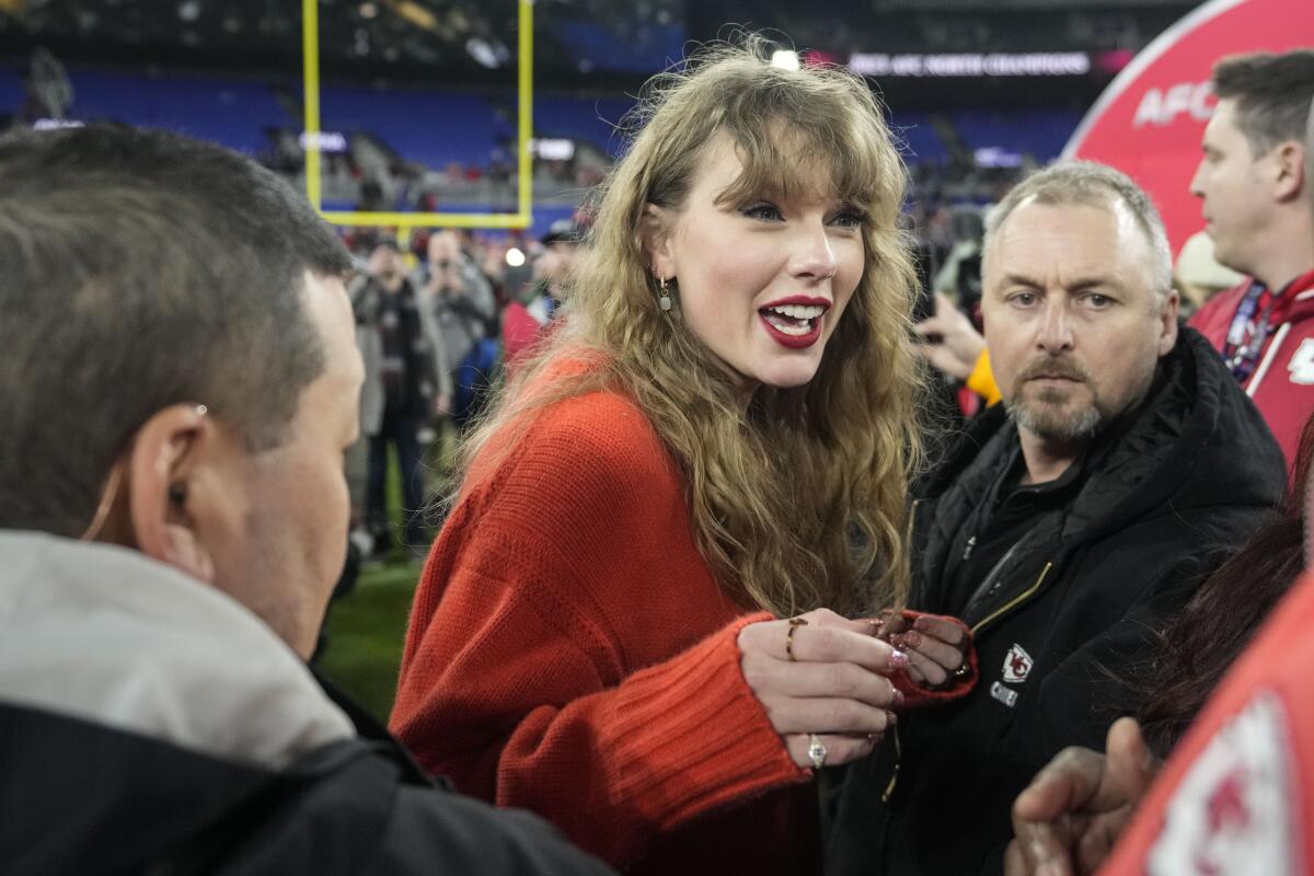 Taylor Swift charla en la cancha después del partido de campeonato AFC NFL entre los Ravens